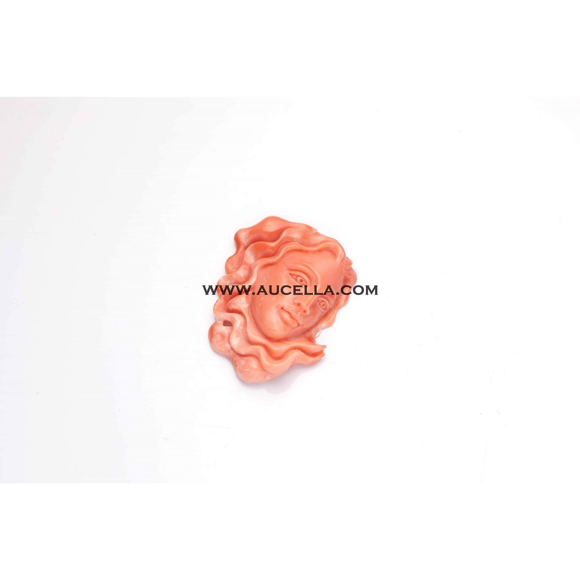 Carved woman face on pink coral