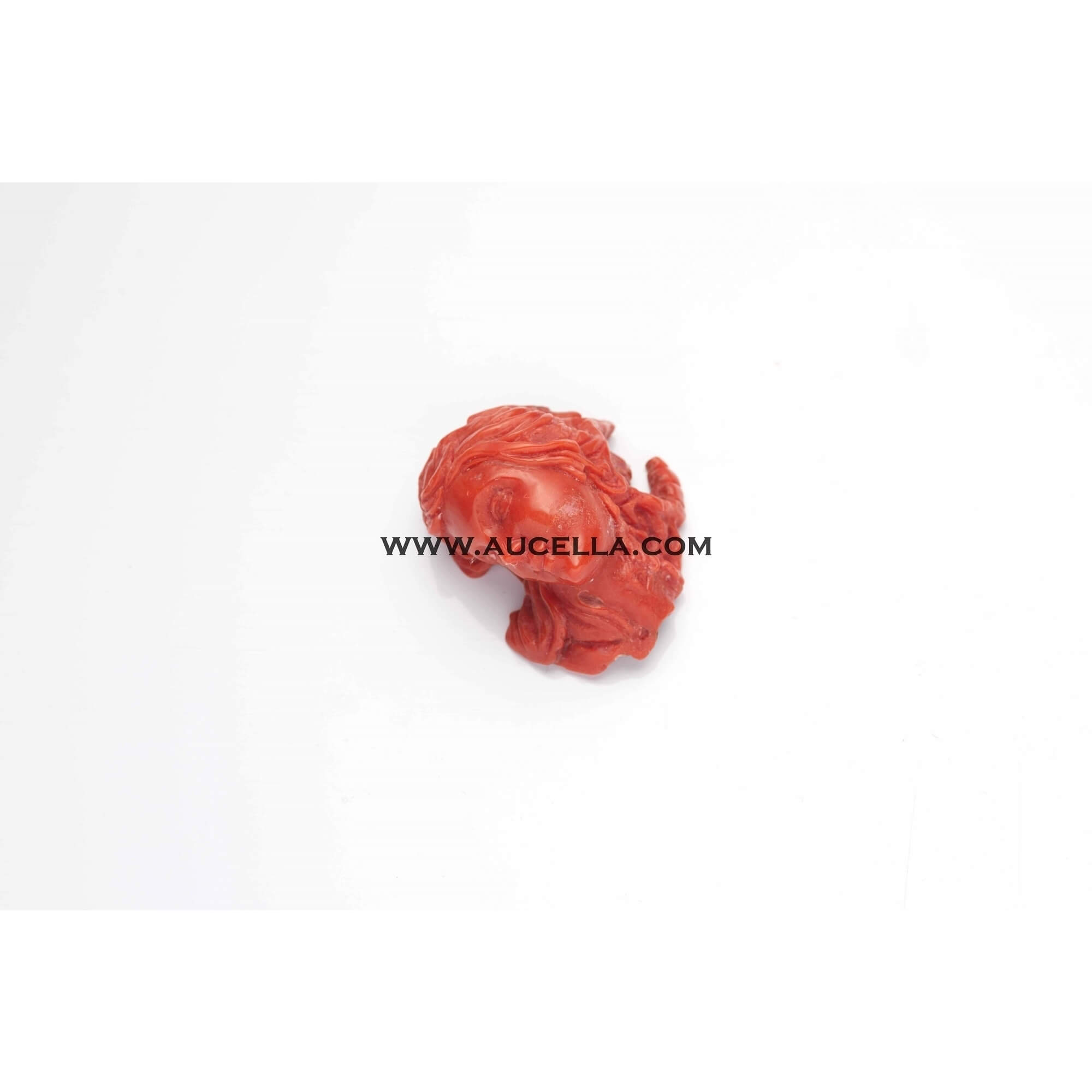 Carved woman face on natural red coral